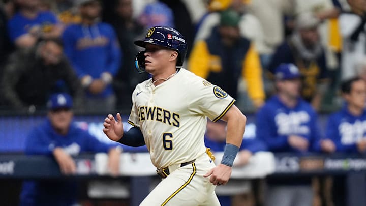 Milwaukee Brewers left fielder Isaac Collins (6) scores after Milwaukee Brewers center fielder Jackson Chourio (11) hits a sacrifice fly to deep right center field during the ninth inning of the National League Championship Series game against the Los Angeles Dodgers October 13, 2025 at American Family Field in Milwaukee, Wisconsin.