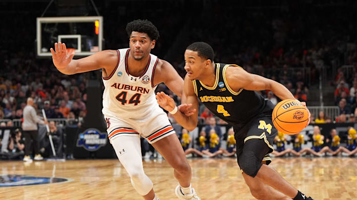 Mar 28, 2025; Atlanta, GA, USA; Michigan Wolverines guard Nimari Burnett (4) drives against Auburn Tigers center Dylan Cardwell (44) in the first half of a South Regional semifinal of the 2025 NCAA tournament at State Farm Arena. Mandatory Credit: Dale Zanine-Imagn Images