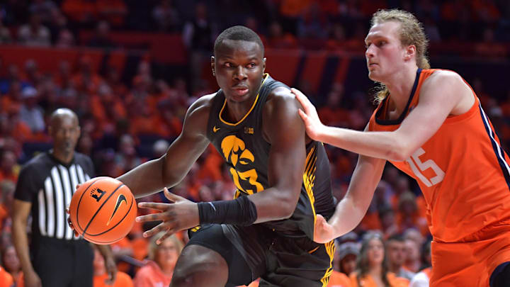 Feb 25, 2025; Champaign, Illinois, USA;  Iowa Hawkeyes forward Ladji Dembele (13) drives the ball against Illinois Fighting Illini forward Jake Davis (15) during the second half at State Farm Center. Mandatory Credit: Ron Johnson-Imagn Images