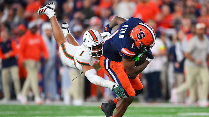 Nov 30, 2024; Syracuse, New York, USA; Miami Hurricanes linebacker Francisco Mauigoa (1) makes a diving tackle on Syracuse Orange running back LeQuint Allen (1) during the second half at the JMA Wireless Dome. Mandatory Credit: Rich Barnes-Imagn Images Nov 30, 2024; Syracuse, New York, USA; Miami Hurricanes linebacker Francisco Mauigoa (1) makes a diving tackle on Syracuse Orange running back LeQuint Allen (1) during the second half at the JMA Wireless Dome. Mandatory Credit: Rich Barnes-Imagn Images