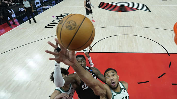 Jan 28, 2025; Portland, Oregon, USA; Milwaukee Bucks power forward Giannis Antetokounmpo (34) grabs a rebound over Portland Trail Blazers center Deandre Ayton (2, left) during the second half at Moda Center. Mandatory Credit: Soobum Im-Imagn Images