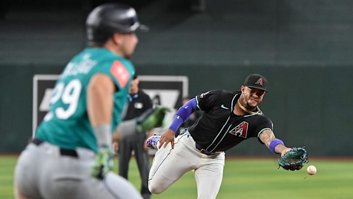 Jun 11, 2025; Phoenix, Arizona, USA;  Arizona Diamondbacks second base Ketel Marte (4) tosses the ball to first baseman as Seattle Mariners catcher Cal Raleigh (29) beats him in the third inning at Chase Field. Mandatory Credit: Matt Kartozian-Imagn Images