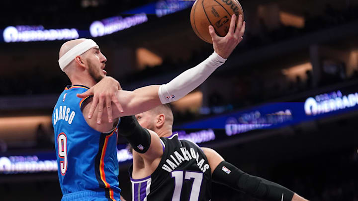 Mar 25, 2025; Sacramento, California, USA; Oklahoma City Thunder guard Alex Caruso (9) is fouled by Sacramento Kings center Jonas Valanciunas (17) in the fourth quarter at the Golden 1 Center. Mandatory Credit: Cary Edmondson-Imagn Images