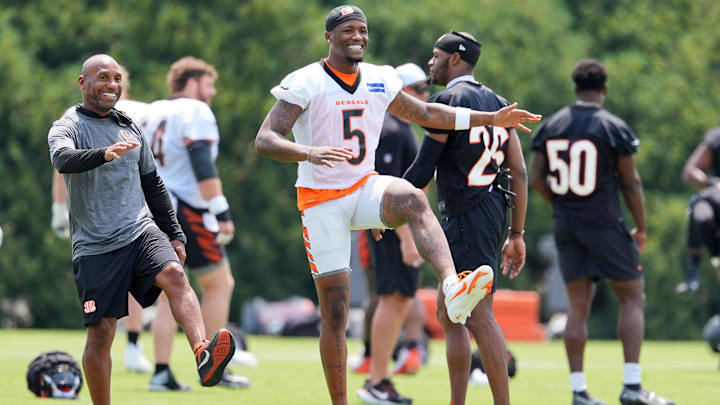 Jul 26, 2024; Cincinnati, OH, USA; Cincinnati Bengals wide receiver Tee Higgins (middle) smiles as he stretches during training camp practice at Kettering Health Practice Fields. Mandatory Credit: Kareem Elgazzar-Imagn Images Jul 26, 2024; Cincinnati, OH, USA; Cincinnati Bengals wide receiver Tee Higgins (middle) smiles as he stretches during training camp practice at Kettering Health Practice Fields. Mandatory Credit: Kareem Elgazzar-Imagn Images