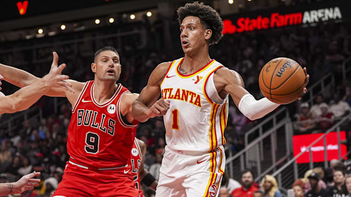 Nov 9, 2024; Atlanta, Georgia, USA; Atlanta Hawks forward Jalen Johnson (1) passes behind Chicago Bulls center Nikola Vucevic (9) during the first half at State Farm Arena. Mandatory Credit: Dale Zanine-Imagn Images