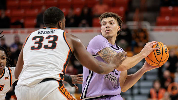 Jan 7, 2025; Stillwater, Oklahoma, USA; Kansas State Wildcats guard Coleman Hawkins (33) looks to pass around Oklahoma State Cowboys forward Abou Ousmane (33) during the second half at Gallagher-Iba Arena. Mandatory Credit: William Purnell-Imagn Images
