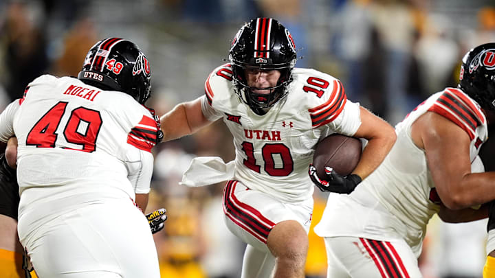 Utah Utes tight end Hunter Andrews (10) carries the ball for a touchdown as tackle Mike Tauteoli (49) blocks in the fourth quarter against the Wyoming Cowboys at Jonah Field at War Memorial Stadium.