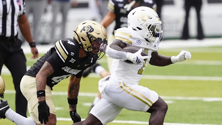 Aug 29, 2025; Boulder, Colorado, USA; Georgia Tech Yellow Jackets running back Jamal Haynes (1) runs past Colorado Buffaloes cornerback Preston Hodge (4) in the first quarter at Folsom Field. Mandatory Credit: Ron Chenoy-Imagn Images
