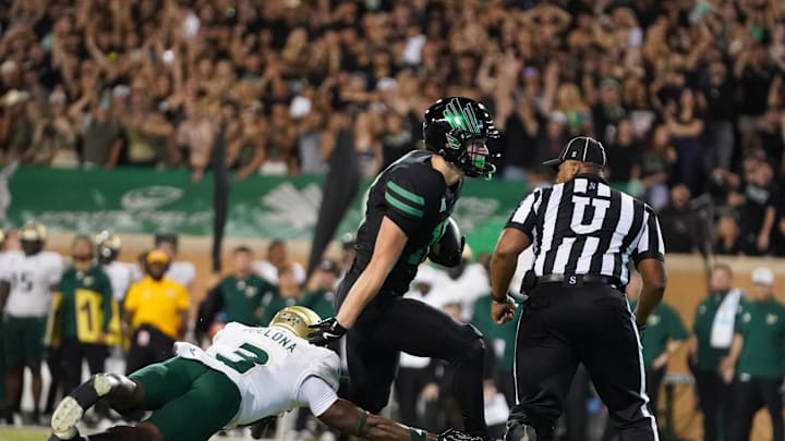 Oct 10, 2025; Denton, Texas, USA; North Texas Mean Green wide receiver Wyatt Young (10) carries the ball for a touchdown as South Florida Bulls cornerback Jonas Duclona (3)defends during the first half of a game at DATCU Stadium. Mandatory Credit: Raymond Carlin III-Imagn Images