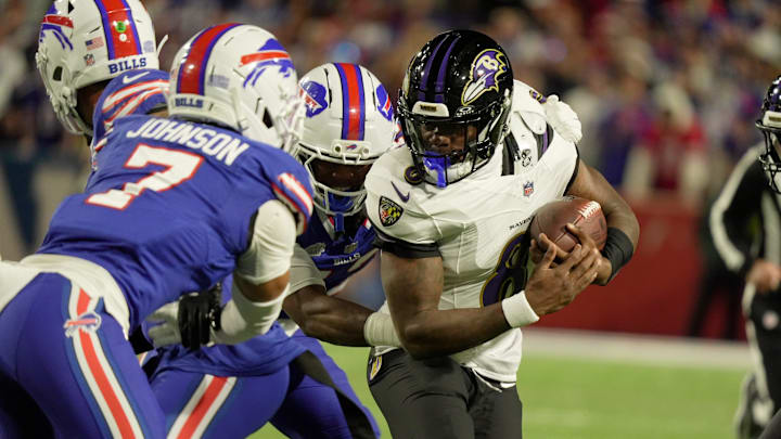 Baltimore Ravens quarterback Lamar Jackson tries to avoid Buffalo Bills cornerback Dorian Strong and cornerback Taron Johnson after picking up a couple yards in Orchard Park on Sept. 7, 2025.