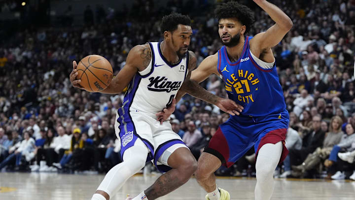 Jan 23, 2025; Denver, Colorado, USA; Sacramento Kings guard Malik Monk (0) drives at Denver Nuggets guard Jamal Murray (27) in the second half at Ball Arena. Mandatory Credit: Ron Chenoy-Imagn Images