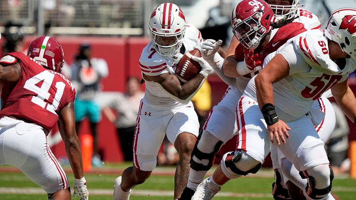 Sep 13, 2025; Tuscaloosa, Alabama, USA;  Wisconsin running back Dilin Jones (7) runs the ball between Alabama linebacker Nikhai Hill-Green (41) and Alabama defensive lineman Edric Hill (94) at Saban Field at Bryant-Denny Stadium. Mandatory Credit: Gary Cosby-USA TODAY Network via Imagn Images