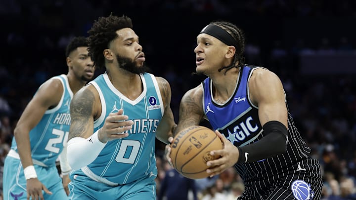 Mar 19, 2026; Charlotte, North Carolina, USA; Orlando Magic forward Paolo Banchero (5) tries to drive to the basket past Charlotte Hornets forward Miles Bridges (0) during the third quarter at Spectrum Center. Mandatory Credit: Brian Westerholt-Imagn Images
