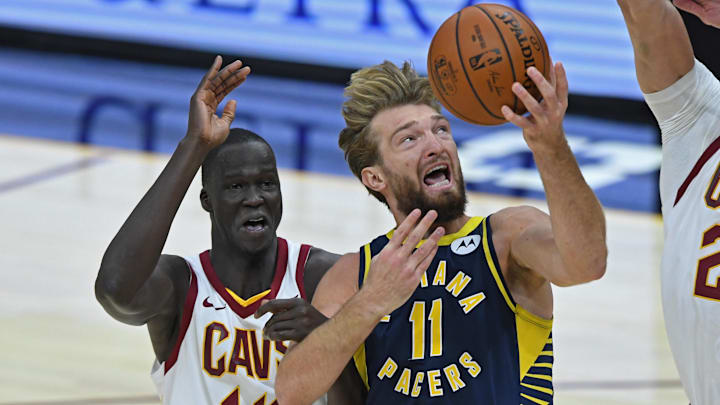Dec 14, 2020; Cleveland, Ohio, USA; Indiana Pacers forward Domantas Sabonis (11) goes to the basket while being grabbed by Cleveland Cavaliers forward Thon Maker (14) during the second quarter at Rocket Mortgage FieldHouse. Mandatory Credit: David Dermer-Imagn Images