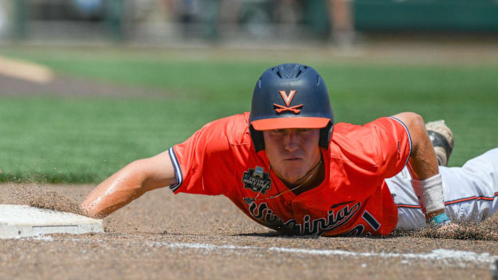 Jun 14, 2024; Omaha, NE, USA;  Virginia Cavaliers third baseman Eric Becker (21) slides back into first base against the North Carolina Tar Heels during the fourth inning at Charles Schwab Filed Omaha. Mandatory Credit: Steven Branscombe-Imagn Images