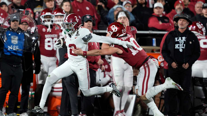 Alabama Crimson Tide defensive back Zabien Brown (2) runs past Oklahoma Sooners quarterback John Mateer (10) as he returns an interception for a touchdown during a first-round College Football Playoff game between the University of Oklahoma Sooners (OU) and the Alabama Crimson Tide at Gaylord Family Ð Oklahoma Memorial Stadium in Norman, Okla., Friday, Dec. 19, 2025.
