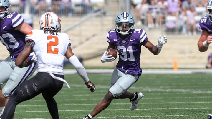Sep 28, 2024; Manhattan, Kansas, USA; Kansas State Wildcats running back DJ Giddens (31) runs the ball against Oklahoma State Cowboys cornerback Korie Black (2) during the fourth quarter at Bill Snyder Family Football Stadium. Mandatory Credit: Scott Sewell-Imagn Images Sep 28, 2024; Manhattan, Kansas, USA; Kansas State Wildcats running back DJ Giddens (31) runs the ball against Oklahoma State Cowboys cornerback Korie Black (2) during the fourth quarter at Bill Snyder Family Football Stadium. Mandatory Credit: Scott Sewell-Imagn Images