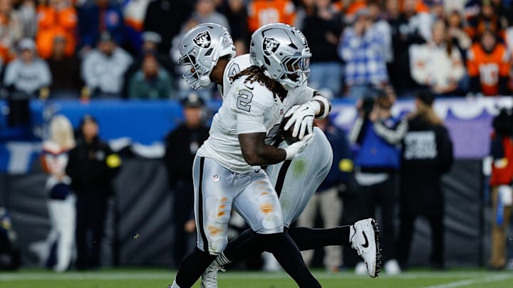 Nov 6, 2025; Denver, Colorado, USA; Las Vegas Raiders quarterback Geno Smith (7) hands the ball off to running back Ashton Jeanty (2) in the fourth quarter against the Denver Broncos at Empower Field at Mile High. Mandatory Credit: Isaiah J. Downing-Imagn Images