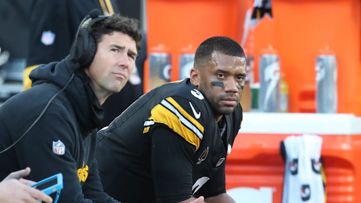 Dec 8, 2024; Pittsburgh, Pennsylvania, USA;  Pittsburgh Steelers quarterbacks coach Tom Arth (left) and quarterback Russell Wilson (3) look on from the bench against the cle/ during the third quarter at Acrisure Stadium. Mandatory Credit: Charles LeClaire-Imagn Images