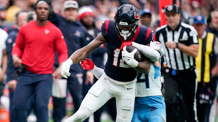 Houston Texans wide receiver Nico Collins (12) is stopped by Tennessee Titans cornerback Elijah Molden (24) during the third quarter at NRG Stadium in Houston, Texas., Sunday, Dec. 31, 2023.