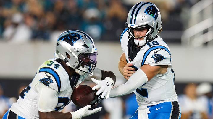 Carolina Panthers quarterback Kenny Pickett (12) hands off to running back Anthony Tyus III 