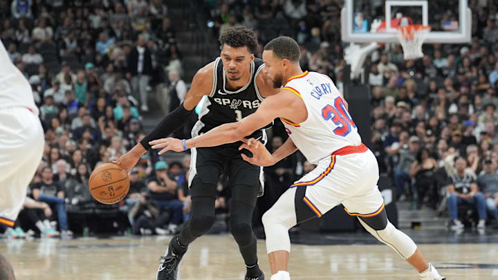 San Antonio Spurs center Victor Wembanyama (1) dribbles against Golden State Warriors guard Stephen Curry (30) in the first half at Frost Bank Center. Mandatory Credit: Daniel Dunn-Imagn Images