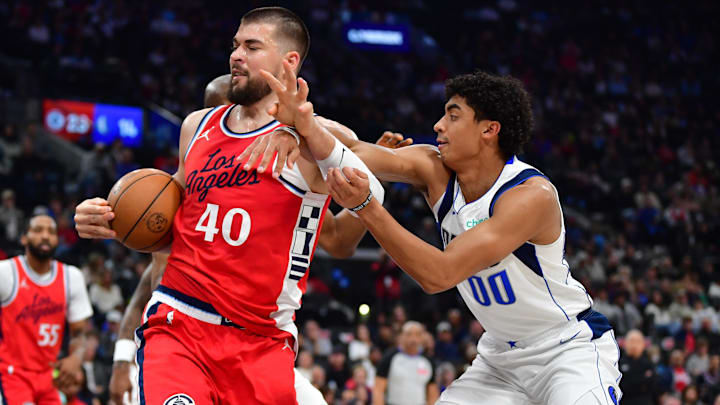 Apr 4, 2025; Inglewood, California, USA;  Los Angeles Clippers center Ivica Zubac (40) gets the rebound against Dallas Mavericks guard Max Christie (00) during the first half at Intuit Dome. Mandatory Credit: Gary A. Vasquez-Imagn Images