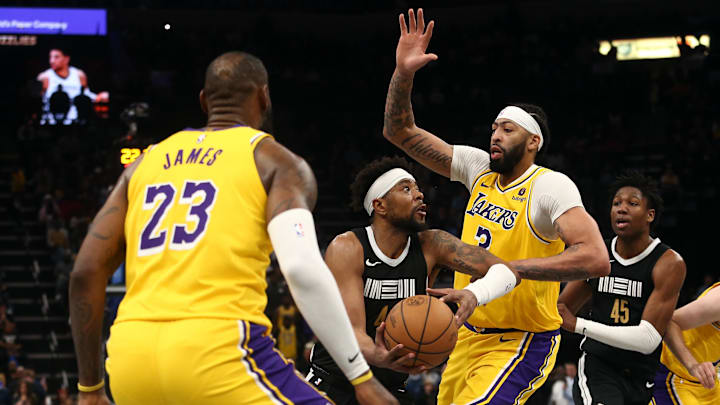 Memphis Grizzlies guard Jordan Goodwin (4) drives to the basket between Los Angeles Lakers forward LeBron James (23) and forward Anthony Davis (3) during the second half at FedExForum. 