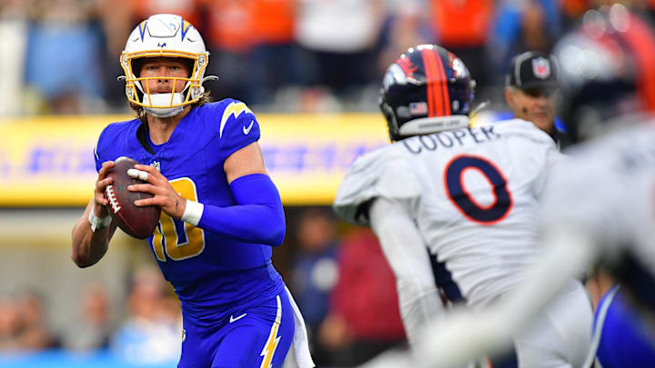 Dec 10, 2023; Inglewood, California, USA; Los Angeles Chargers quarterback Justin Herbert (10) moves out to pass against the defense of Denver Broncos linebacker Jonathon Cooper (0) during the first half at SoFi Stadium. Mandatory Credit: Gary A. Vasquez-Imagn Images
