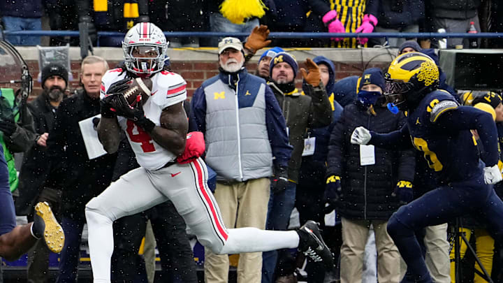Ohio State Buckeyes wide receiver Jeremiah Smith (4) catches a touchdown pass in front of Michigan Wolverines defensive back Zeke Berry (10) during the NCAA football game at Michigan Stadium in Ann Arbor, Mich. on Nov. 29, 2025. Ohio State Buckeyes wide receiver Jeremiah Smith (4) catches a touchdown pass in front of Michigan Wolverines defensive back Zeke Berry (10) during the NCAA football game at Michigan Stadium in Ann Arbor, Mich. on Nov. 29, 2025.