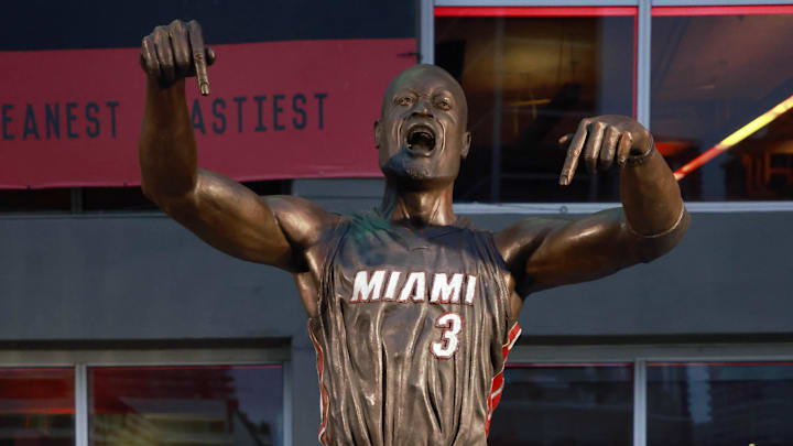 Oct 28, 2024; Miami, Florida, USA;  Former Miami Heat guard Dwyane Wade poses with his statue in front of the Kaseya Center. 