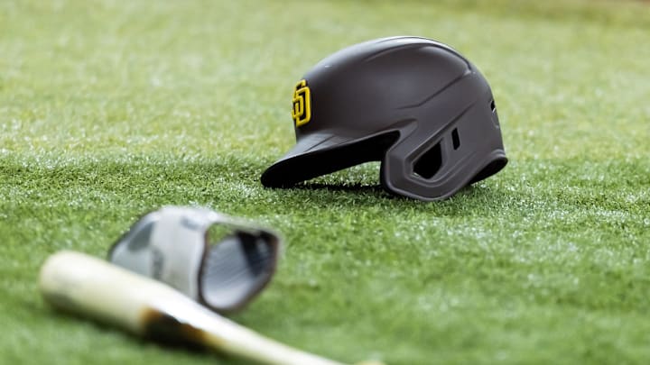 Jun 13, 2025; Phoenix, Arizona, USA; Detailed view of a San Diego Padres batting helmet and baseball bat on the field at Chase Field. 
