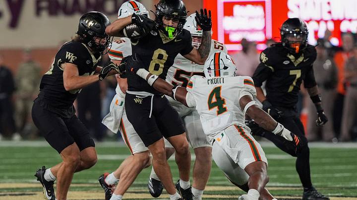 Sep 18, 2026; Winston-Salem, North Carolina, USA;  Wake Forest Demon Deacons wide receiver Carlos Hernandez (8) eludes Miami (FL) Hurricanes linebacker Cameron Pruitt (4) during the second half at Allegacy Federal Credit Union Stadium.  Mandatory Credit: Jim Dedmon-Imagn Images