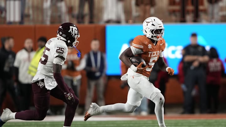 Nov 28, 2025; Austin, Texas, USA; Texas Longhorns running back Quintrevion Wisner (5) runs for yards past Texas A&M Aggies safety Dalton Brooks (25) during the second half at Darrell K Royal-Texas Memorial Stadium. Mandatory Credit: Scott Wachter-Imagn Images