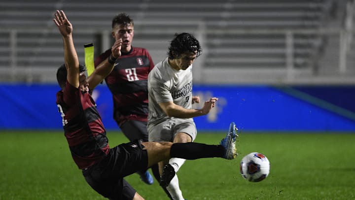 Dec 13, 2019; Cary, NC, USA; Georgetown Hoyas midfielder Paul Rothrock (3) kicks as Stanford Cardinal midfielder Logan Panchot (22) and defender Keegan Tingey (21) defend in the second half at WakeMed Soccer Park. Mandatory Credit: Bob Donnan-Imagn Images
