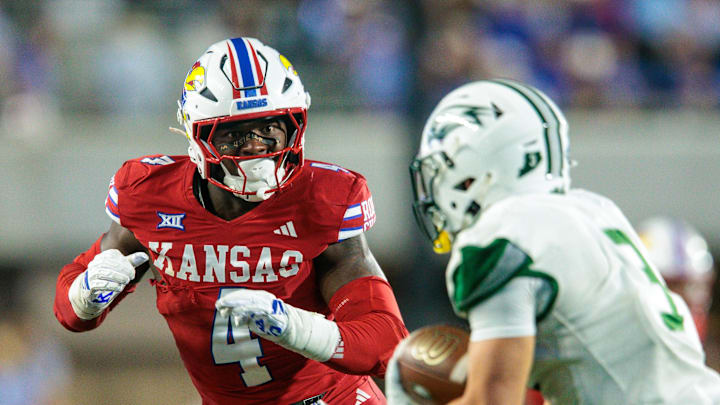 Aug 29, 2025; Lawrence, Kansas, USA; Kansas Jayhawks linebacker Trey Lathan (4) looks to tackle Wagner Seahawks running back Matt Morad (3) during the second half at David Booth Kansas Memorial Stadium. Mandatory Credit: William Purnell-Imagn Images