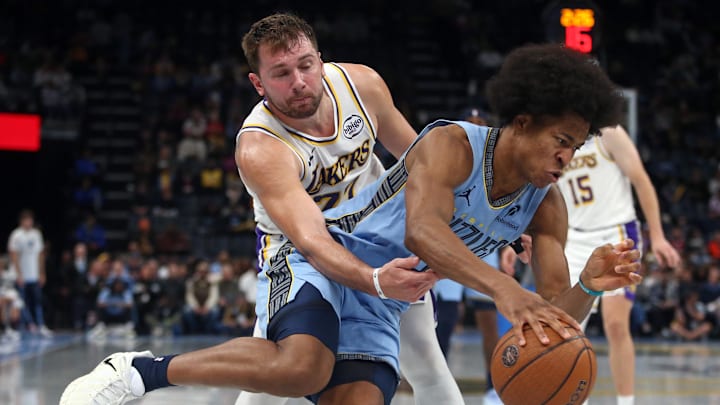 Oct 31, 2025; Memphis, Tennessee, USA; Memphis Grizzlies forward Jaylen Wells (0) drives to the basket as Los Angeles Lakers guard Luka Doncic (77) defends during the fourth quarter at FedExForum. Mandatory Credit: Petre Thomas-Imagn Images