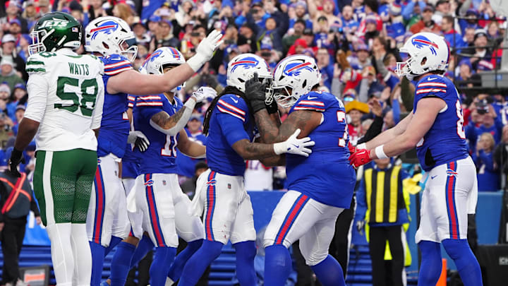 Dec 29, 2024; Orchard Park, New York, USA; Buffalo Bills offensive tackle Dion Dawkins (73) congratulates Buffalo Bills running back James Cook (4) for scoring a touchdown against the New York Jets during the second half at Highmark Stadium. 