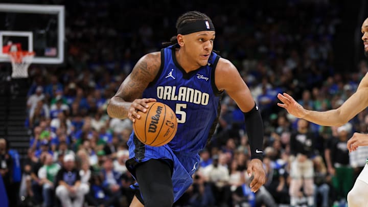 Apr 27, 2025; Orlando, Florida, USA; Orlando Magic forward Paolo Banchero (5) is guarded by Boston Celtics guard Derrick White (9) in the second quarter during game four of first round for the 2025 NBA Playoffs at Kia Center. Mandatory Credit: Nathan Ray Seebeck-Imagn Images