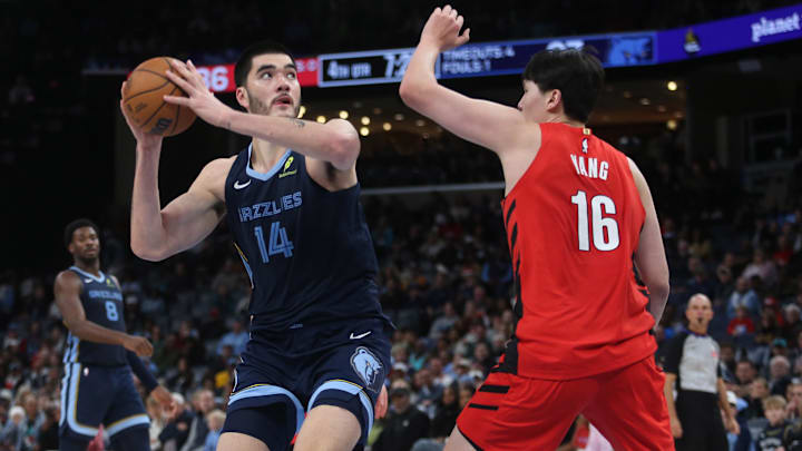 Dec 7, 2025; Memphis, Tennessee, USA; Memphis Grizzlies center Zach Edey (14) spins to the basket as Portland Trail Blazers center Yang Hansen (16) defends during the fourth quarter at FedExForum. Mandatory Credit: Petre Thomas-Imagn Images
