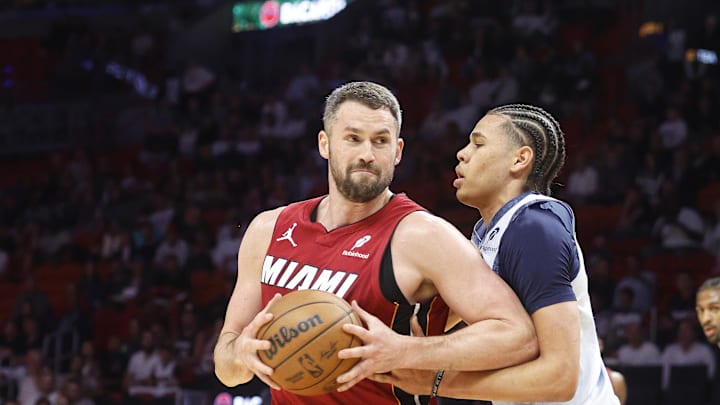 Mar 3, 2025; Miami, Florida, USA;  Washington Wizards forward Kyshawn George (18)defends Miami Heat forward Kevin Love (42) during the first half at Kaseya Center. Mandatory Credit: Rhona Wise-Imagn Images