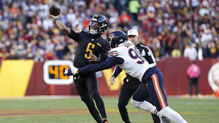 Oct 27, 2024; Landover, Maryland, USA; Washington Commanders quarterback Jayden Daniels (5) passes the ball as Chicago Bears defensive end Montez Sweat (98) chases during the first quarter at Northwest Stadium. Mandatory Credit: Geoff Burke-Imagn Images