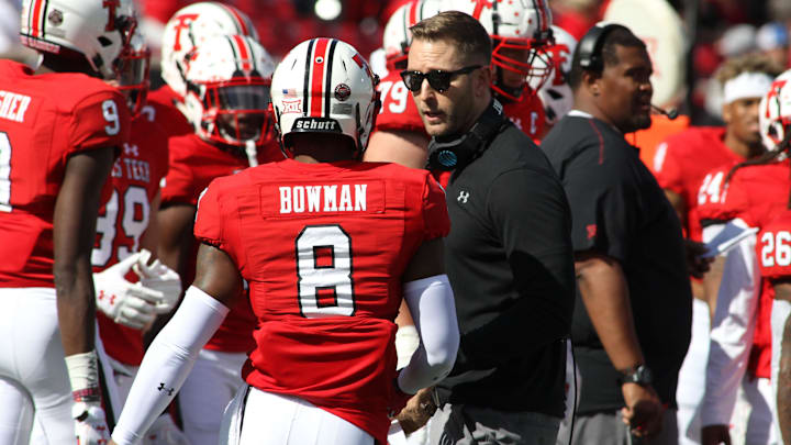Oct 20, 2018; Lubbock, TX, USA; Texas Tech Red Raiders head coach Kliff Kingsbury (ceneter) talks to punt returner De'Quan Bowman (8) during the game against the Kansas Jayhawks at Jones AT&T Stadium. Texas Tech defeated Kansas 48-16.  Mandatory Credit: Michael C. Johnson-Imagn Images