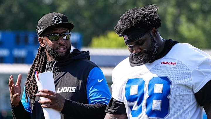 Detroit Lions defensive coordinator Kelvin Sheppard, left, talks to defensive tackle DJ Reader (98) as they walks off the field after practice during training camp at Meijer Performance Center in Allen Park on Monday, July 21, 2025.