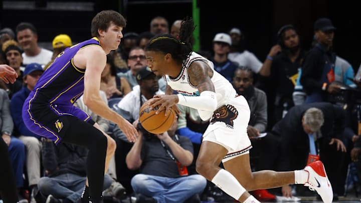 Nov 6, 2024; Memphis, Tennessee, USA; Memphis Grizzlies guard Ja Morant (12) drives to the basket around Los Angeles Lakers guard Austin Reaves (15) during the first half at FedExForum. Mandatory Credit: Petre Thomas-Imagn Images