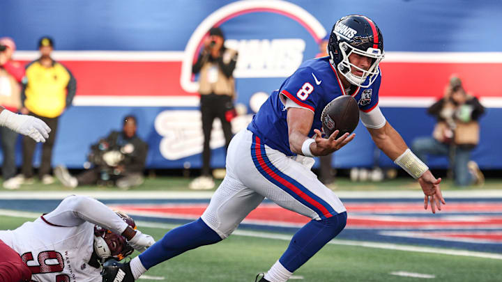 Nov 3, 2024; East Rutherford, New Jersey, USA;  New York Giants quarterback Daniel Jones (8) looses control of the ball while being tackled by Washington Commanders defensive end Dorance Armstrong (92) on an two point conversion attempt during the second half at MetLife Stadium. Mandatory Credit: Vincent Carchietta-Imagn Images