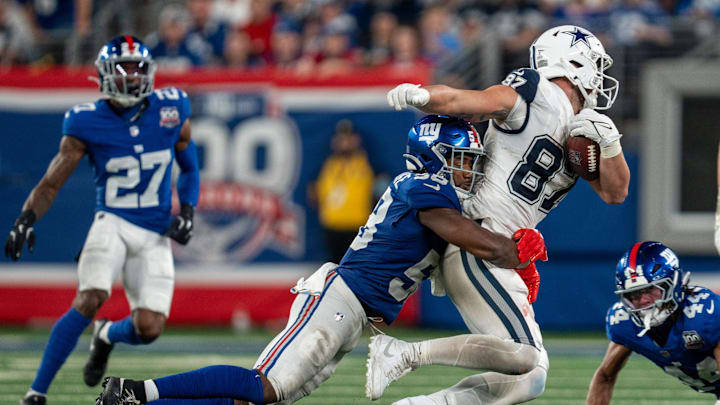 Sep 26, 2024; East Rutherford, NJ, US; Dallas Cowboys tight end Jake Ferguson (87) is taken down after catching a pass by New York Giants linebacker Bobby Okereke (58) at MetLife Stadium.  