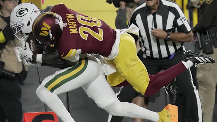 Sep 11, 2025; Green Bay, Wisconsin, USA; Green Bay Packers wide receiver Jayden Reed (11) is injured while being tackled by Washington Commanders safety Quan Martin (20) during the first quarter  at Lambeau Field. Mandatory Credit: Mark Hoffman-USA TODAY Network via Imagn Images