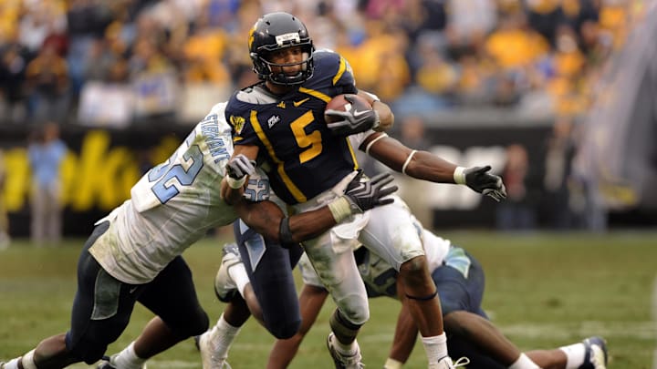 Dec. 27, 2008; Charlotte, NC, USA; West Virginia Mountaneers quarterback Pat White (5) runs as North Carolina Tar Heels linebacker Quan Sturdivant (52) defends in the Mountaineers 31-30 victory against the North Tar Heels at Bank of America Stadium. Mandatory Credit: Bob Donnan-Imagn Images Dec. 27, 2008; Charlotte, NC, USA; West Virginia Mountaneers quarterback Pat White (5) runs as North Carolina Tar Heels linebacker Quan Sturdivant (52) defends in the Mountaineers 31-30 victory against the North Tar Heels at Bank of America Stadium. Mandatory Credit: Bob Donnan-Imagn Images