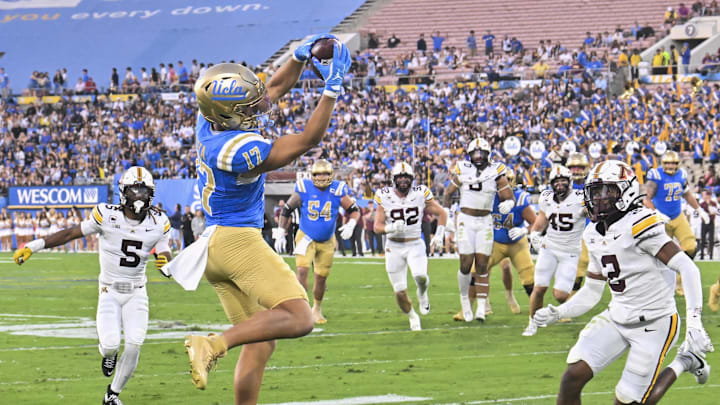 Oct 12, 2024; Pasadena, California, USA;  UCLA Bruins wide receiver Logan Loya (17) leaps to make a catch against Minnesota Golden Gophers defensive back Ethan Robinson (2) during the first quarter at Rose Bowl. Mandatory Credit: Robert Hanashiro-Imagn Images